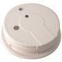 A white smoke detector is sitting on a white surface.