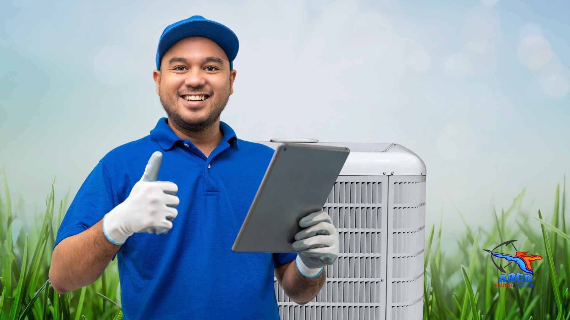 A man in a blue shirt is holding a tablet and giving a thumbs up.