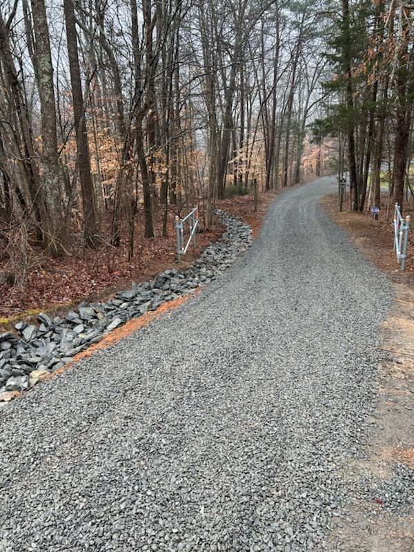 Gravel driveway curving through leafless woods in late autumn