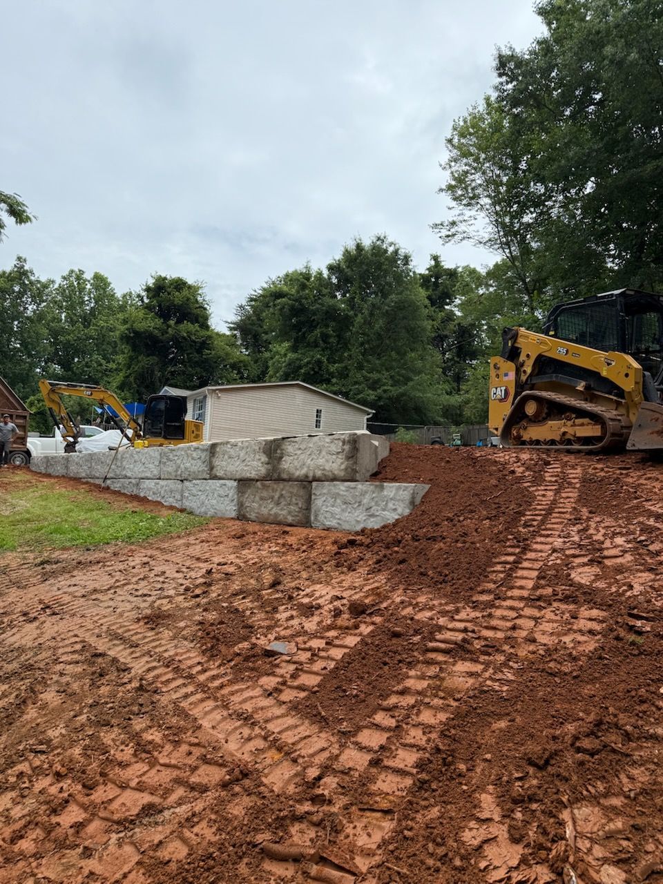 Construction site with excavators and stacked concrete blocks on muddy ground