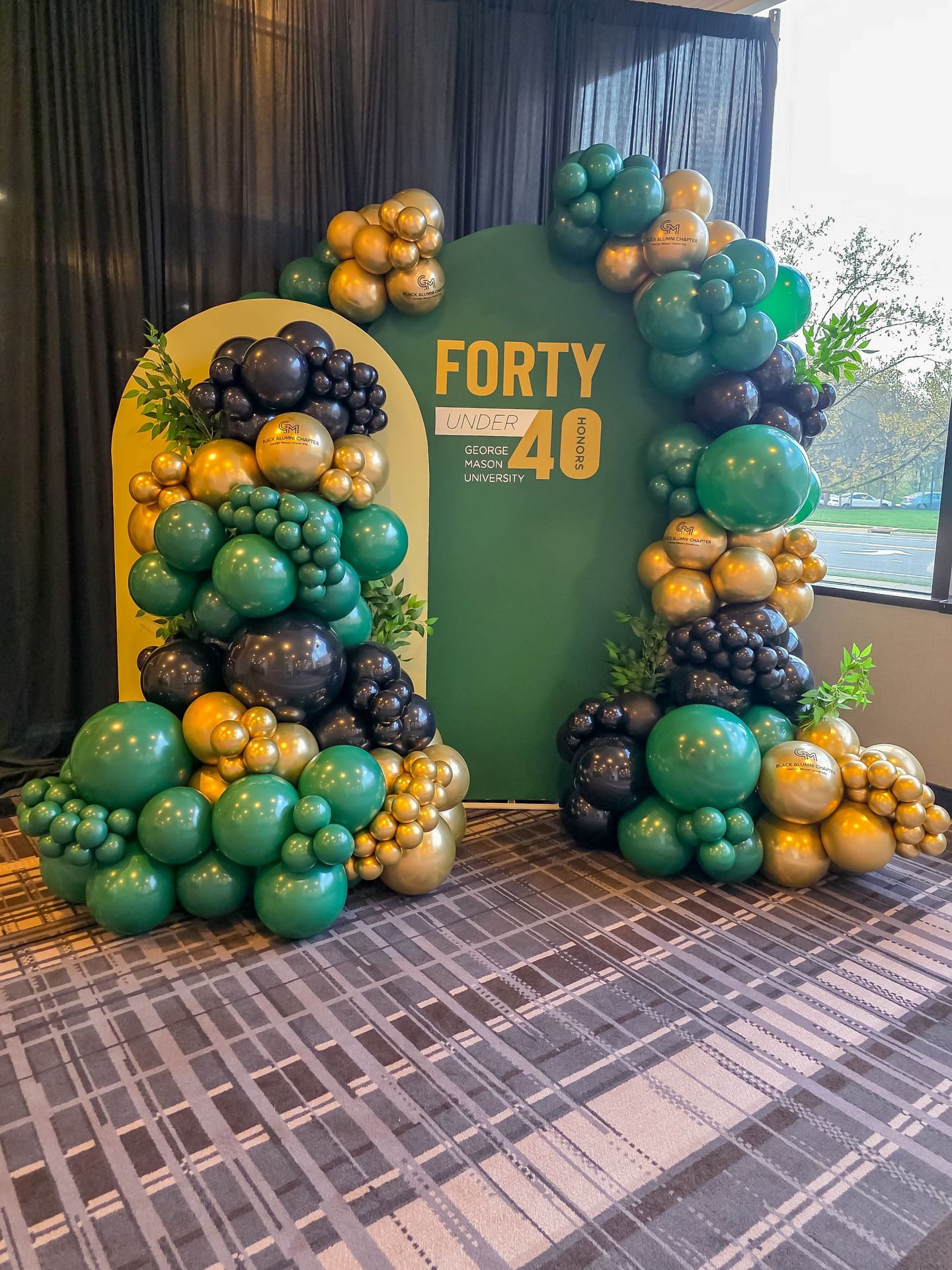 Green and gold balloon arch and backdrop 