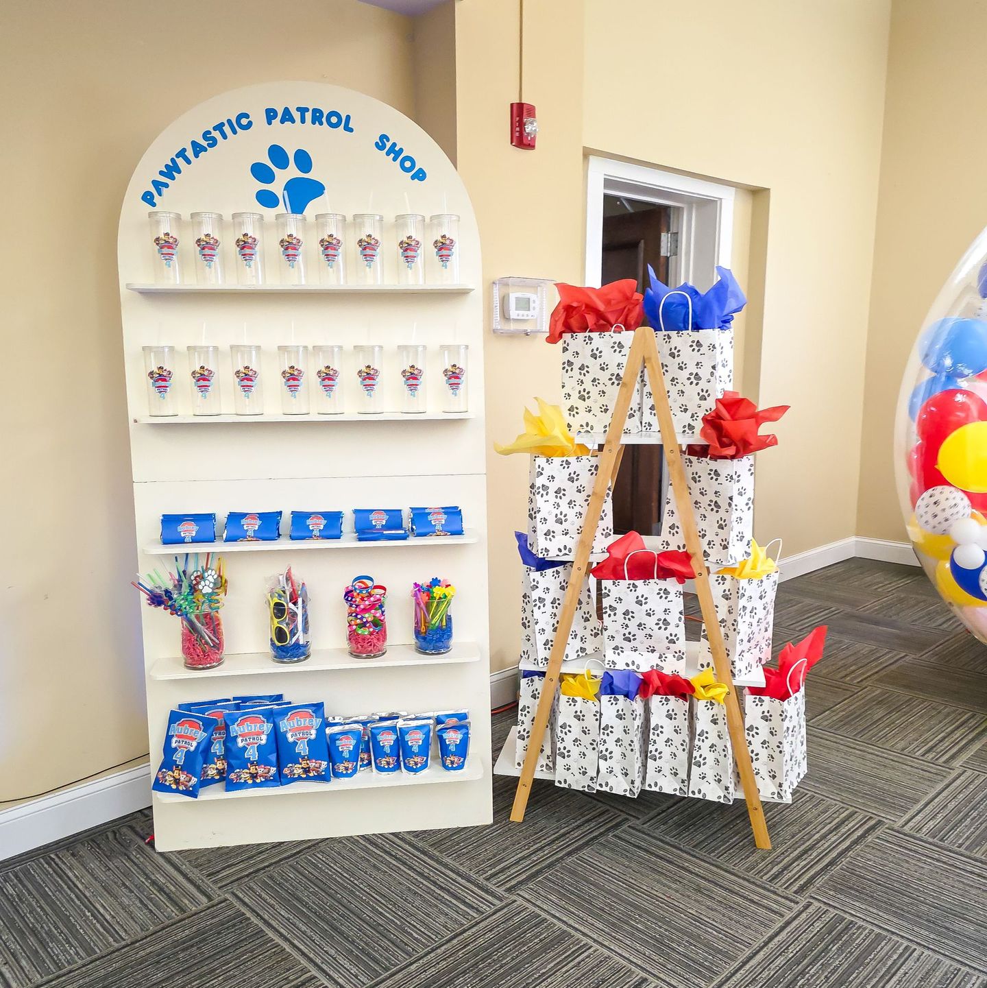Paw-tastic Patrol shop display with treats, gifts, and balloons.