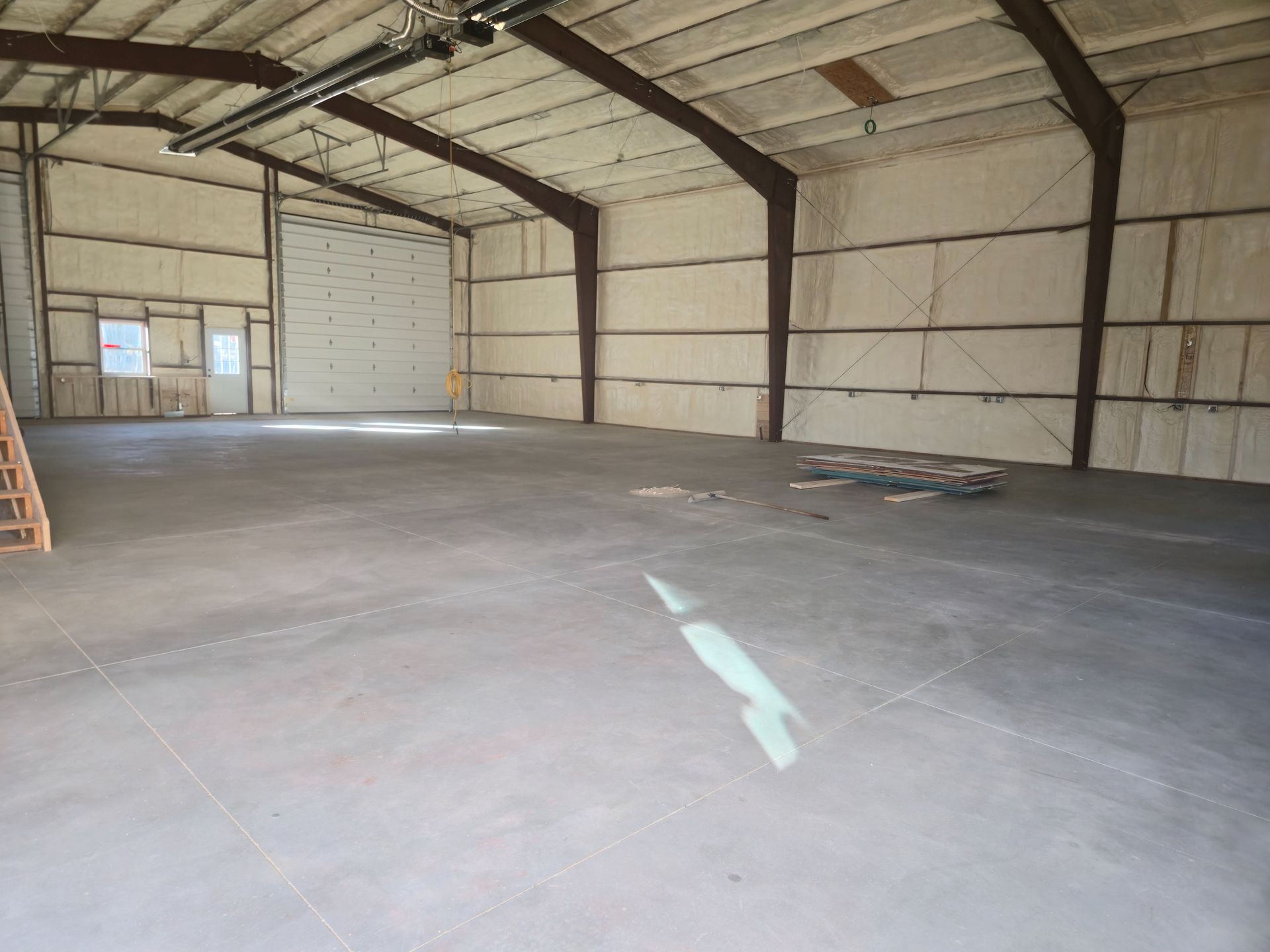 Empty metal warehouse interior with concrete floor and exposed beams