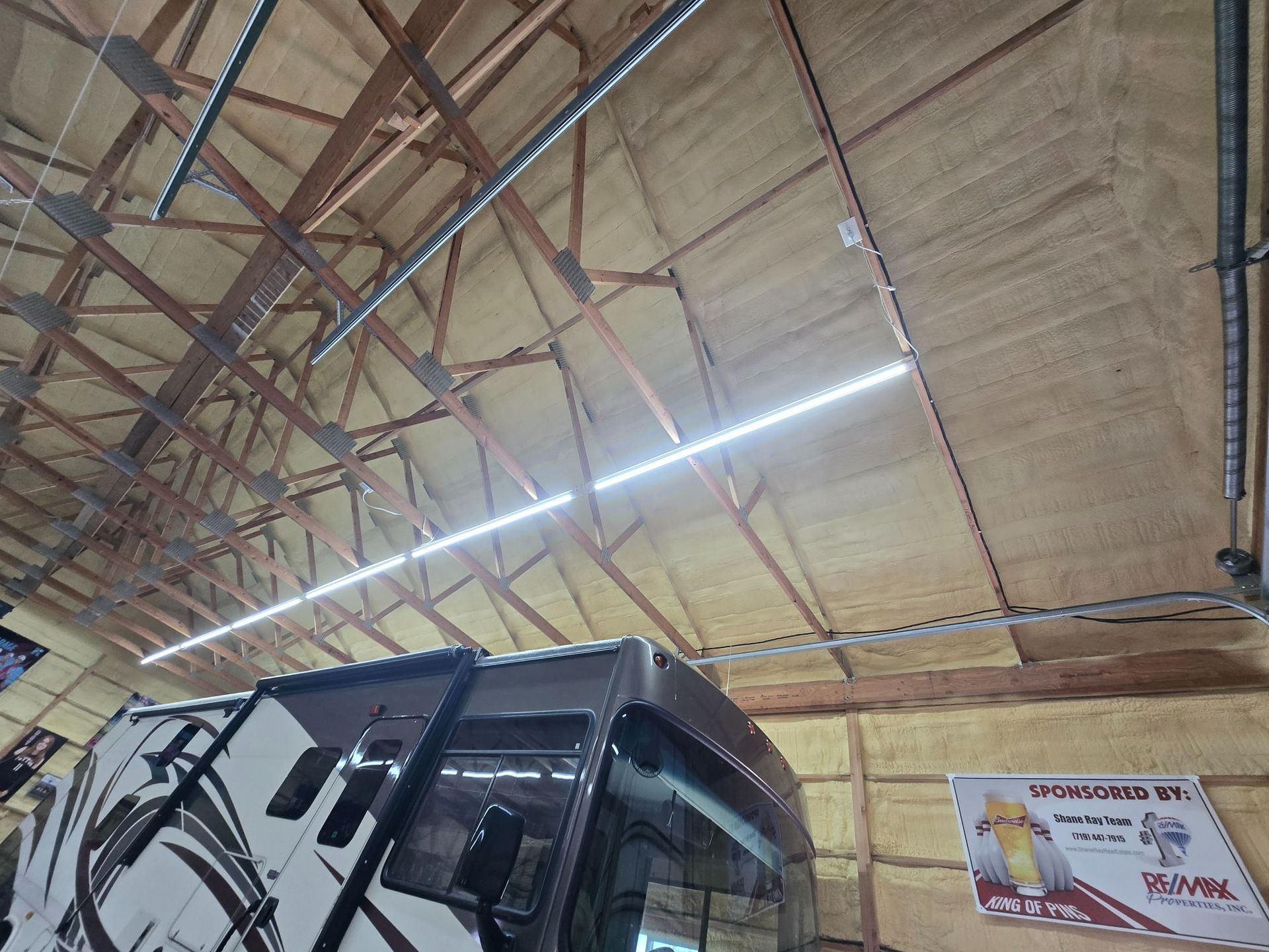 Truck inside a warehouse with a high insulated ceiling and a bright overhead light strip