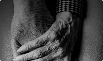 Two hands clasped together in a black-and-white close-up