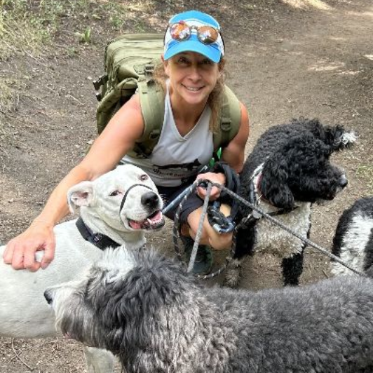 Lisa taking a selfie with a group of dogs