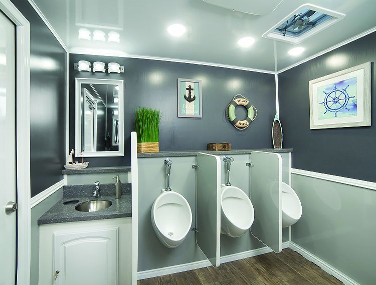 Men's restroom with three urinals, a sink, and nautical decor in a trailer. Gray and white color scheme.