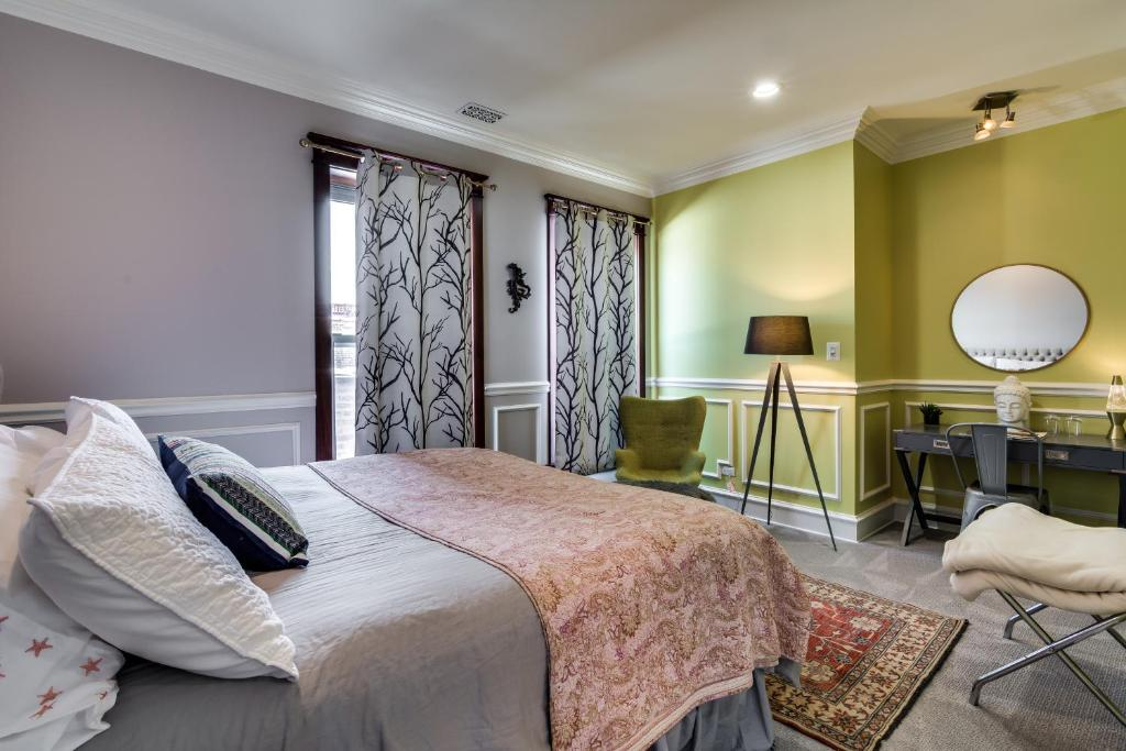 Bedroom with bed, desk, green chair, curtains, and two-toned walls (purple and lime green).