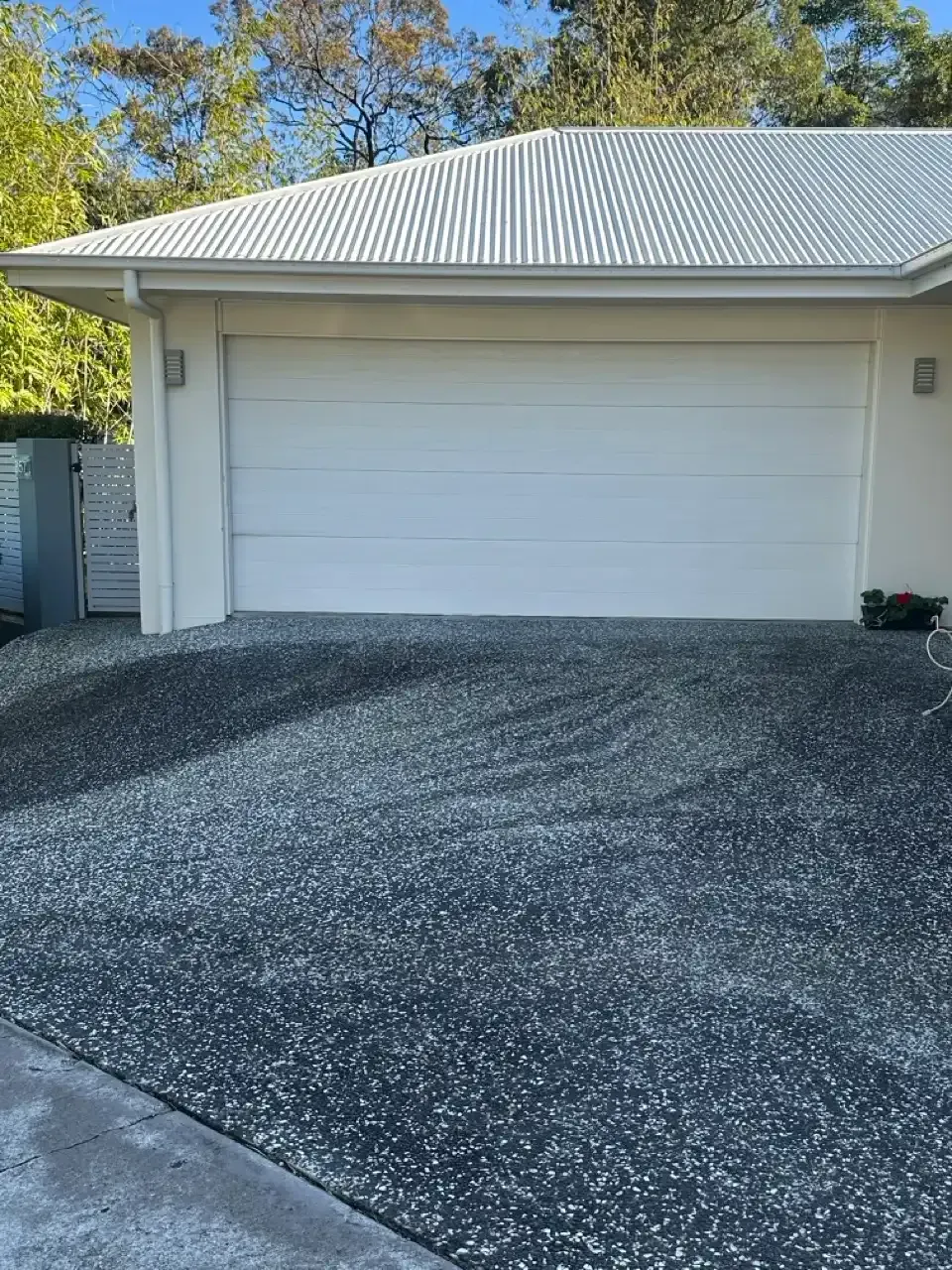 Dark stained exposed aggregate driveway before pressure cleaning in Carindale, Brisbane
