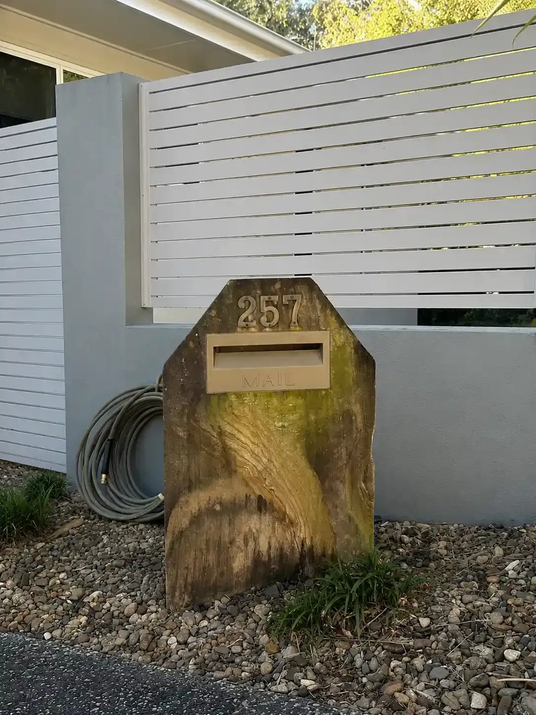 Moss-covered sandstone letterbox before pressure cleaning in Carindale, Brisbane