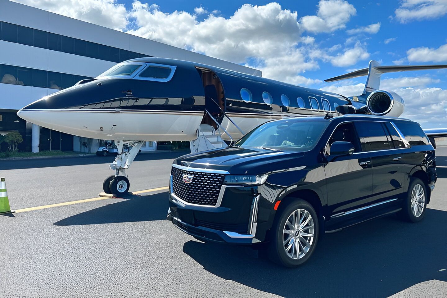 Black SUV parked next to a private jet on a tarmac under a blue sky.