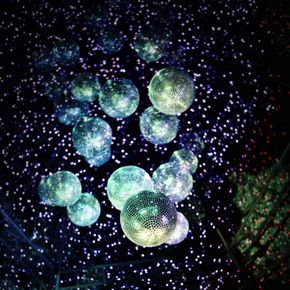 Cluster of illuminated disco balls against a backdrop of small, twinkling lights.