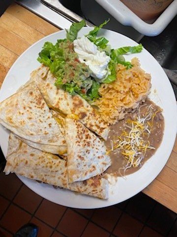 A white plate topped with quesadillas beans and rice