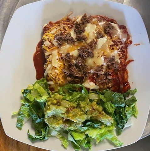 A plate of food with lettuce and guacamole on it