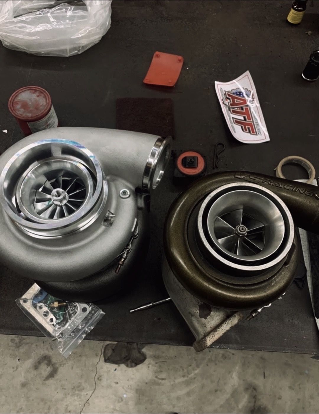 Two turbochargers are sitting next to each other on a table.