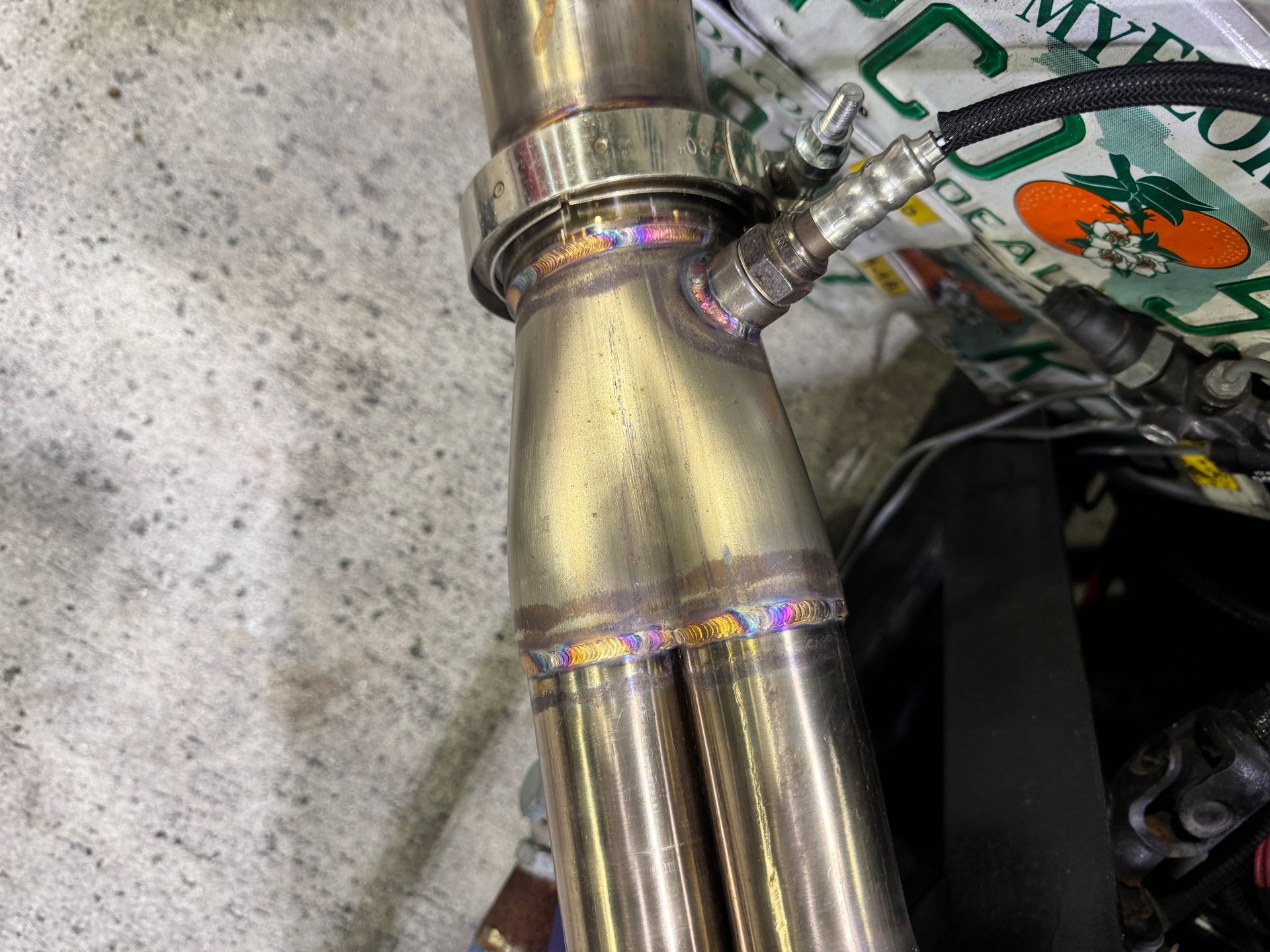 A close up of a metal pipe with a bag of tomatoes in the background.