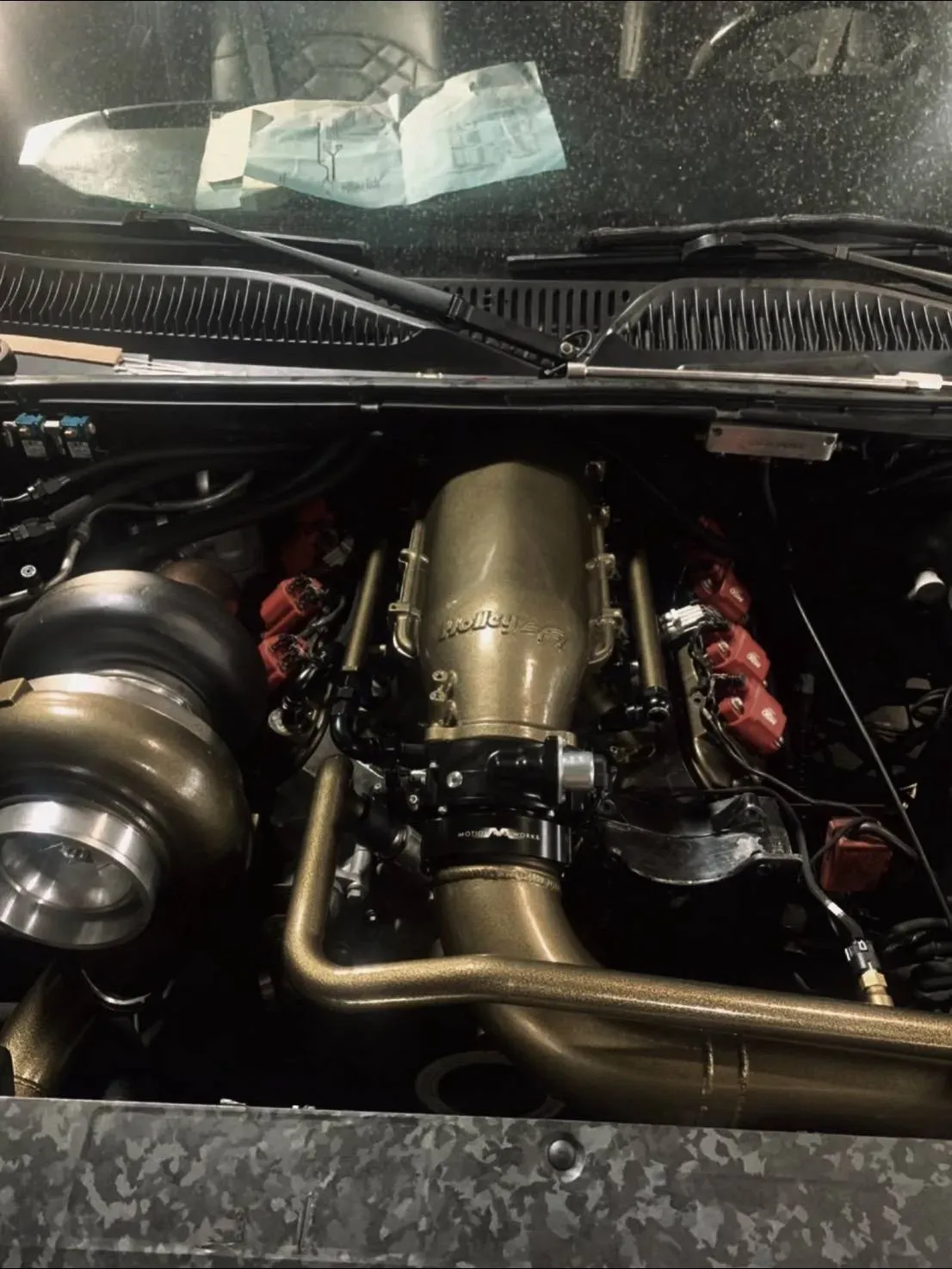 A close up of a car engine with the hood open
