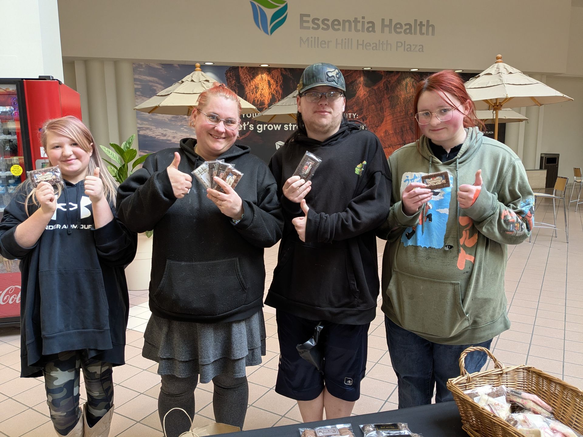Four people holding up GamGams Chocolate Bars they just purchased while at the Duluth Miller Mall.