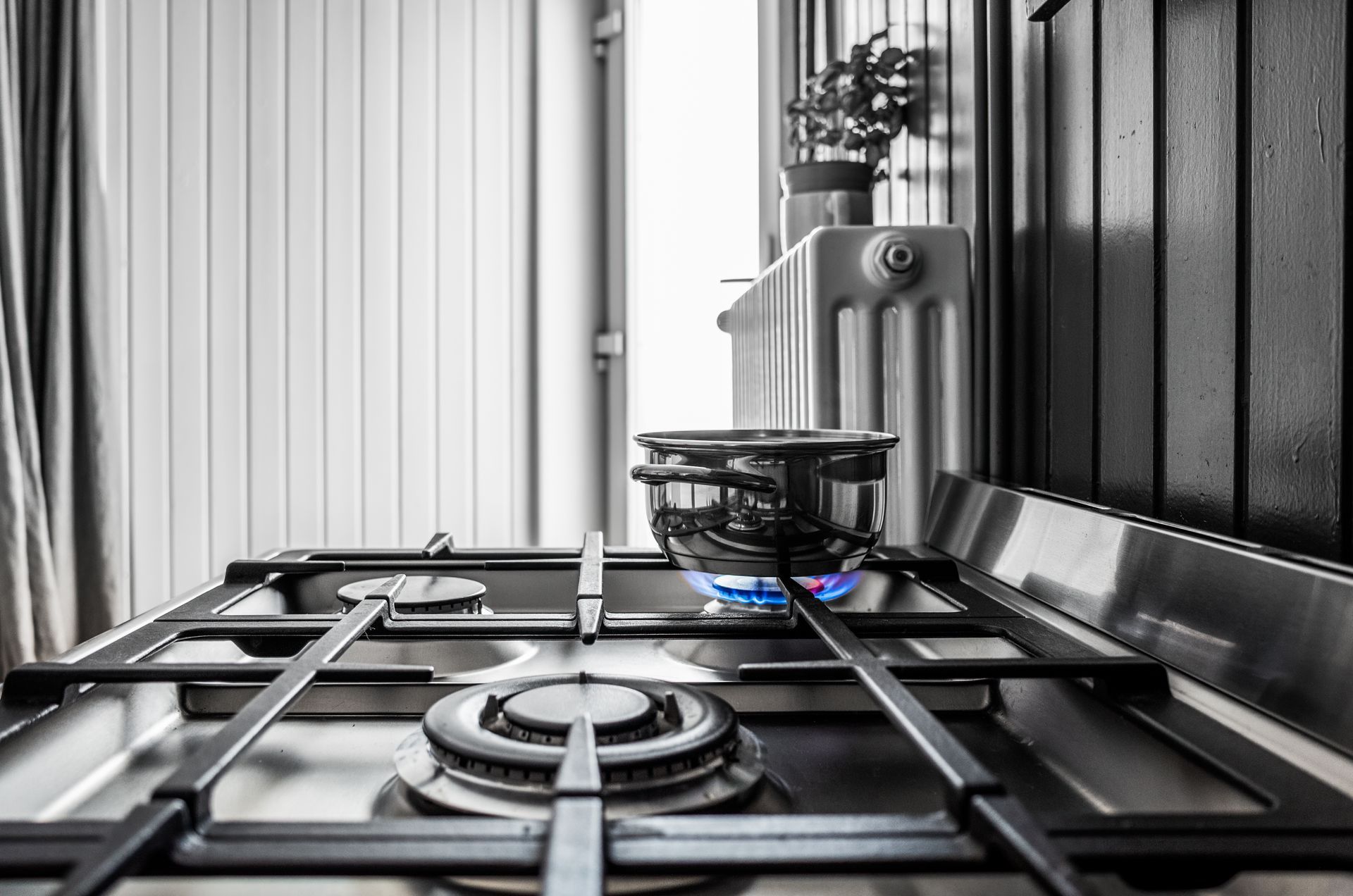 A pot is cooking on a gas stove in a kitchen.