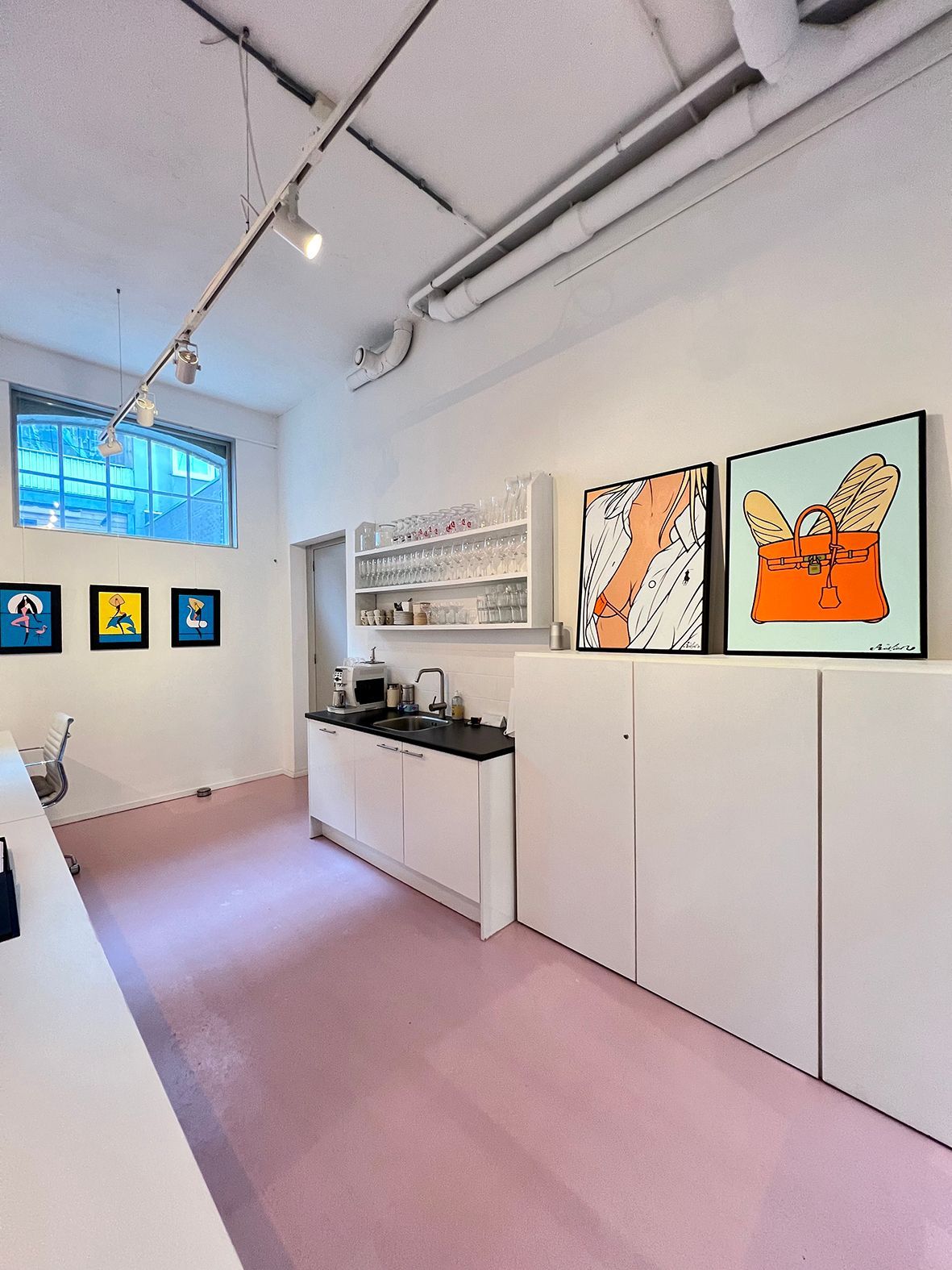 A bright art studio with white walls, pink floor, and two framed abstract paintings.Rental Space Venue at De Hallen Amsterdam