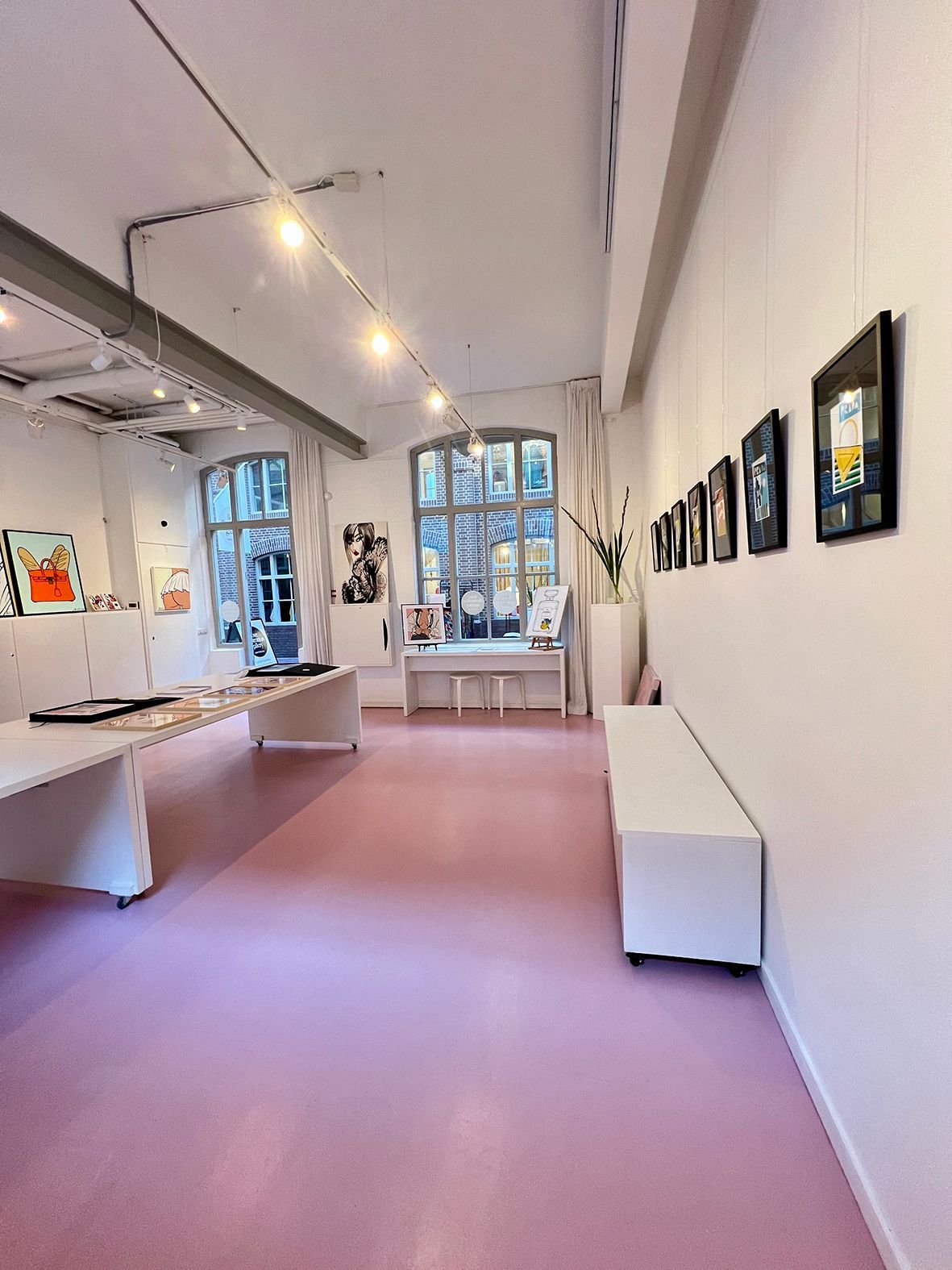 Art gallery interior with pink floor, white walls, artwork displayed, and natural light.Rental Space Venue at De Hallen Amsterdam