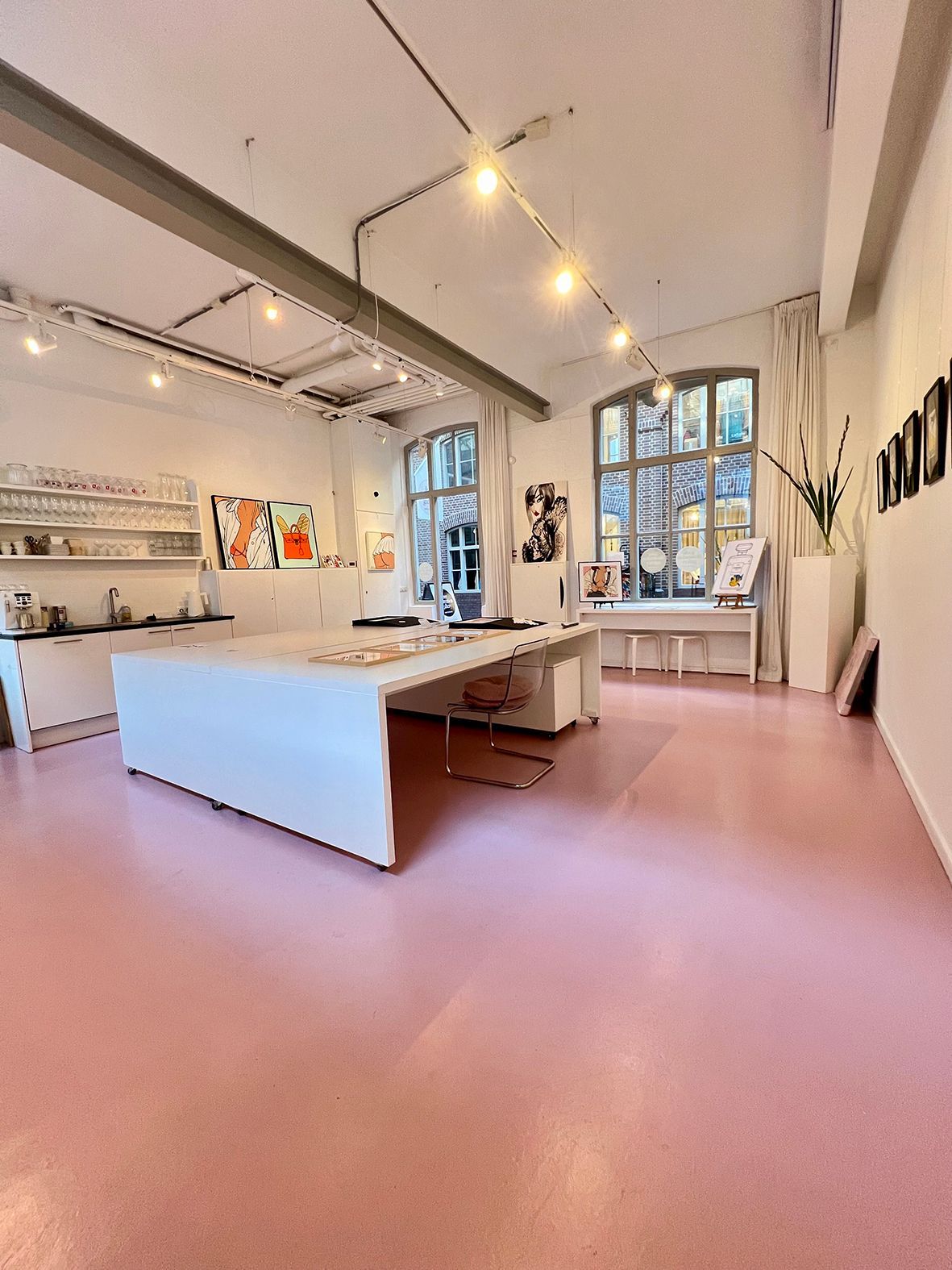 Pink-floored art studio with white counters, table, and art pieces. Natural light from windows. Rental Space Venue at De Hallen Amsterdam