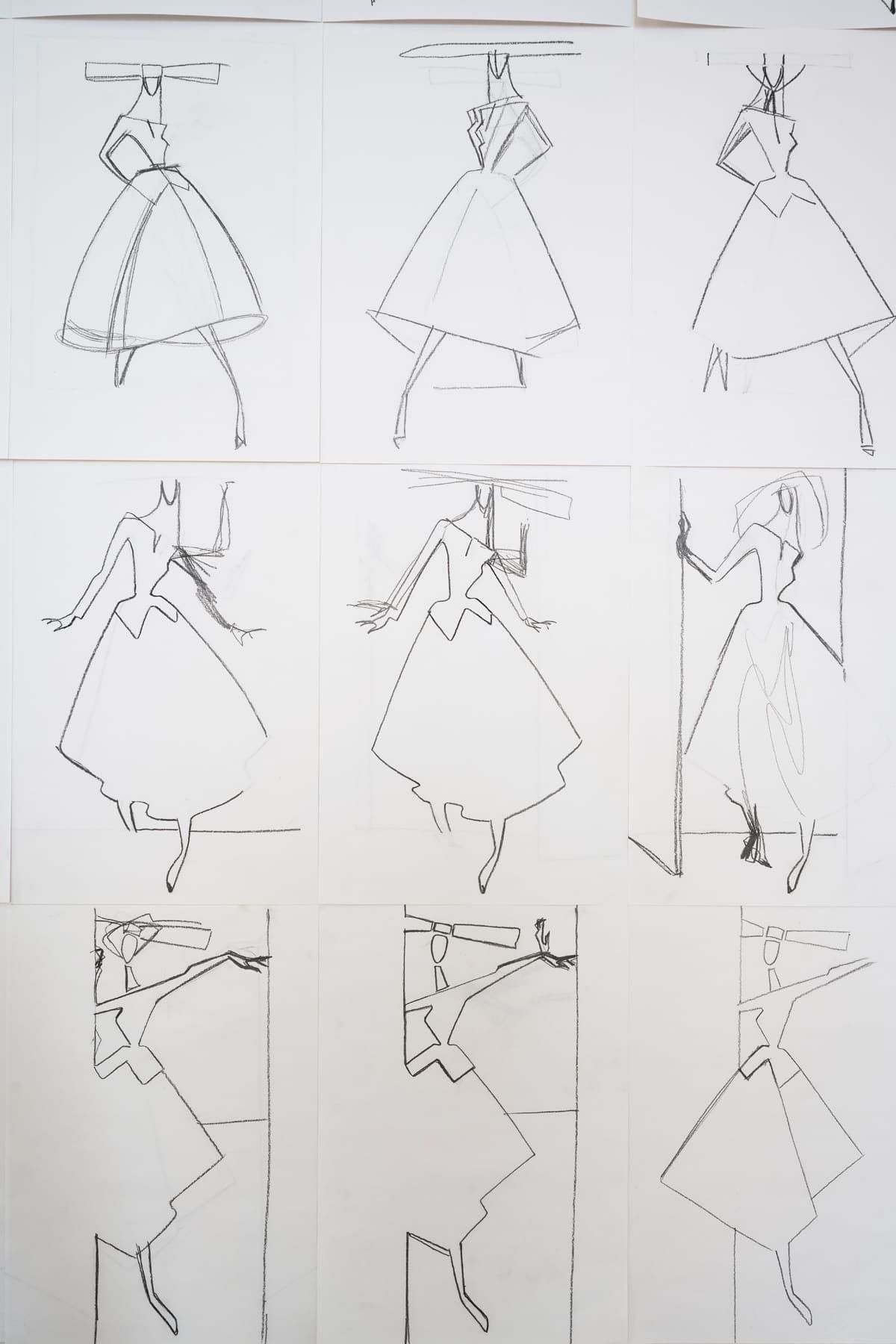 Nine sketches of dresses and figures, likely fashion design concepts, arranged in a grid pattern.