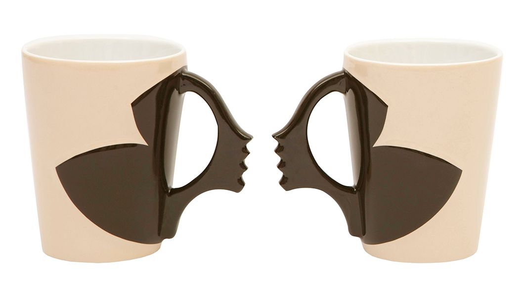 Two beige mugs with brown handles shaped like faces, facing each other.