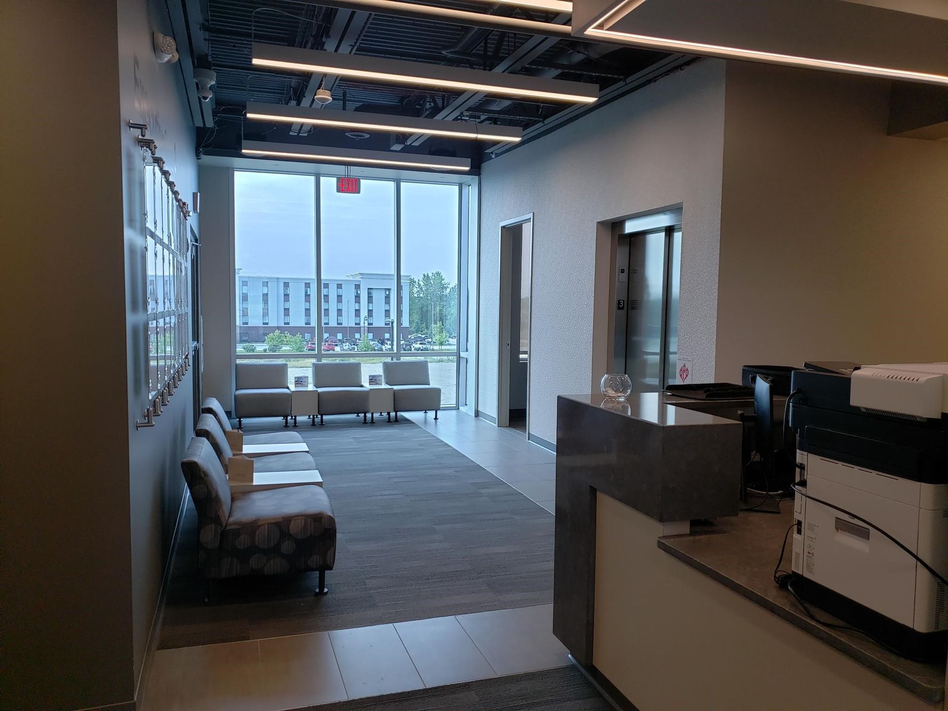 A waiting room with chairs and a printer in it