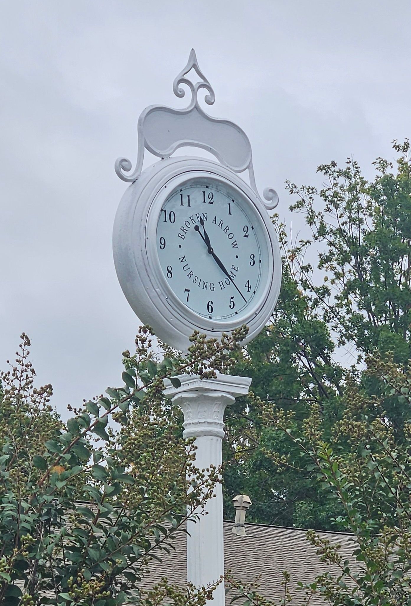 A white clock on a pole shows the time as 4:20