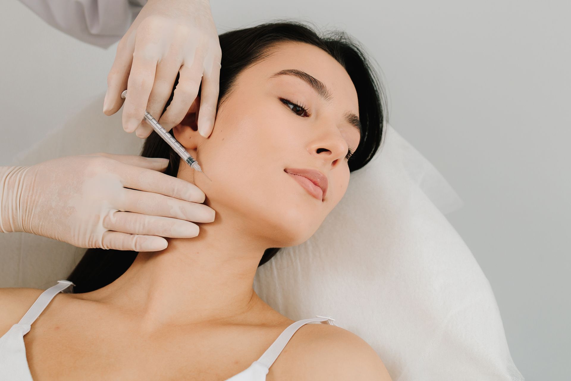 Ein Mann bekommt eine Botox-Injektion in den Nacken.