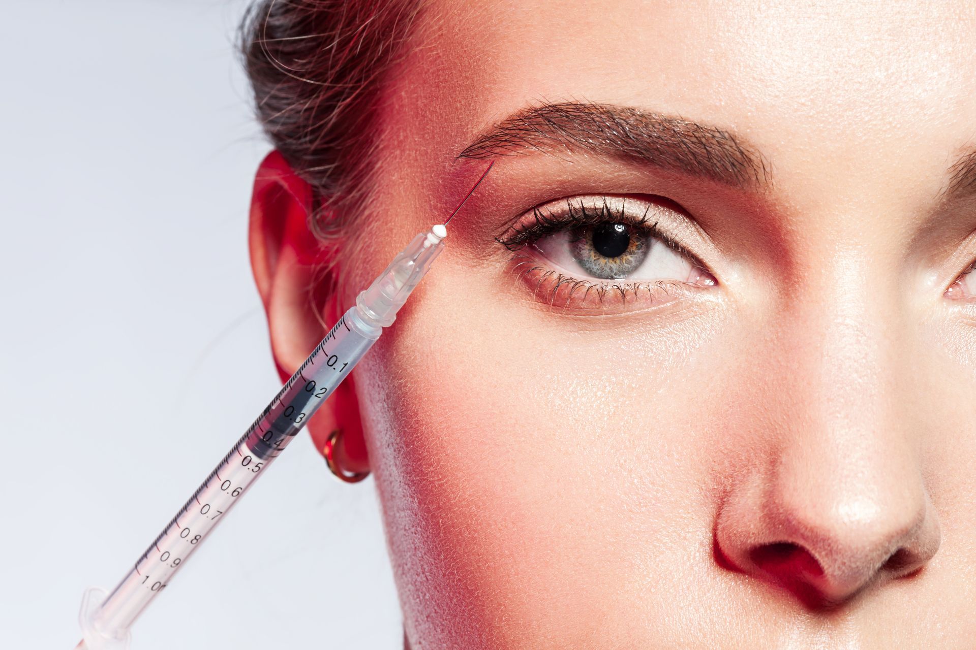 Eine Frau bekommt eine Botox-Injektion in die Stirn.