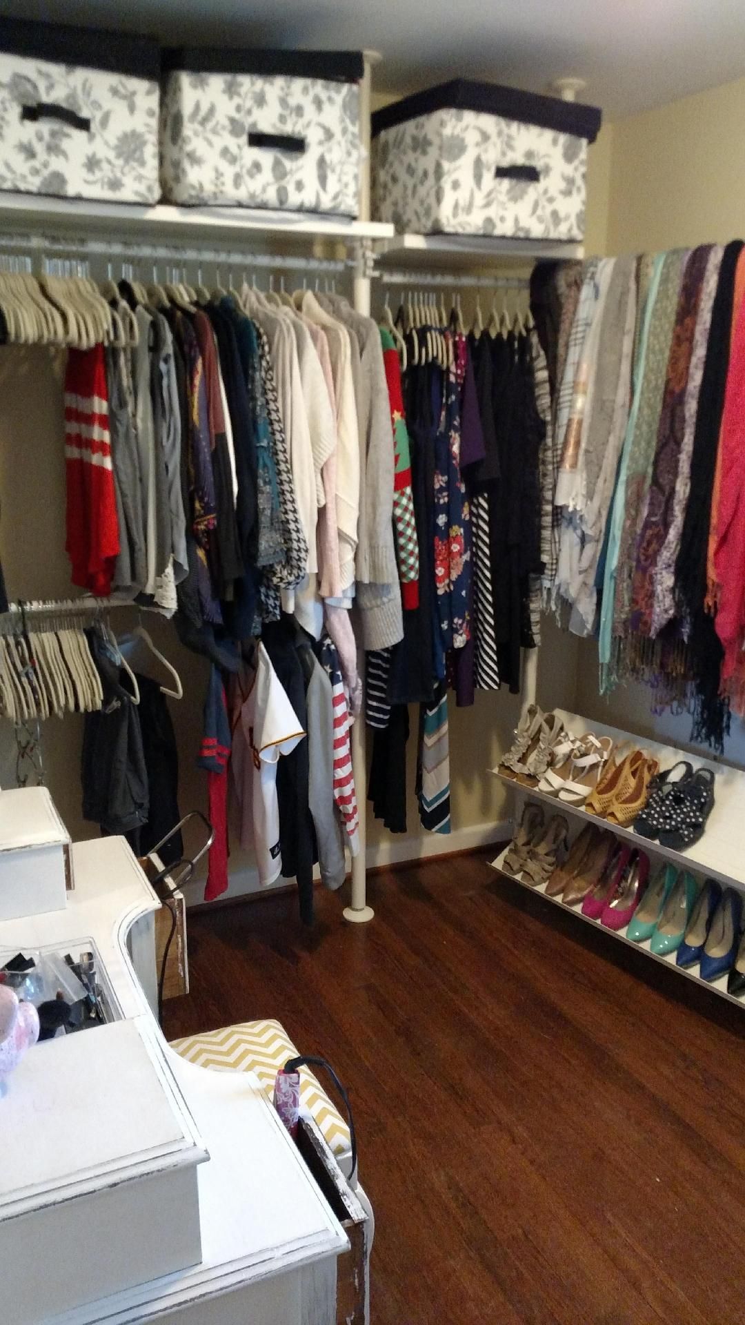A walk in closet filled with lots of clothes and shoes.