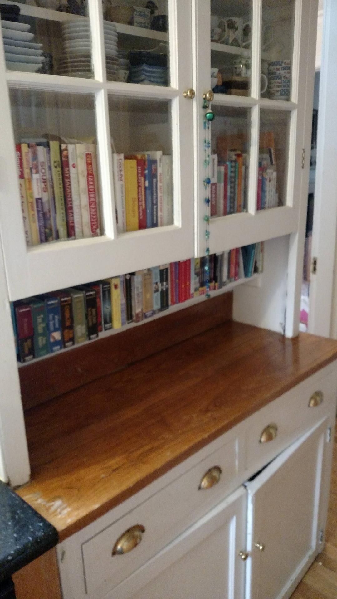 A kitchen cabinet with lots of books on it