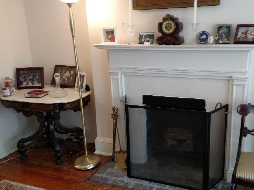 A living room with a fireplace and a clock on the mantle