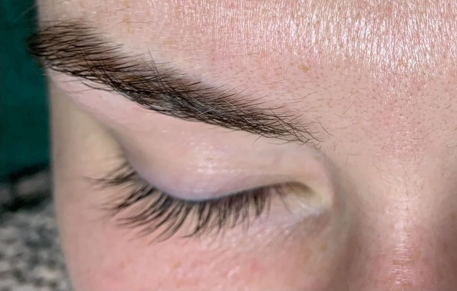 A close up of a woman 's face with long eyelashes and eyebrows.