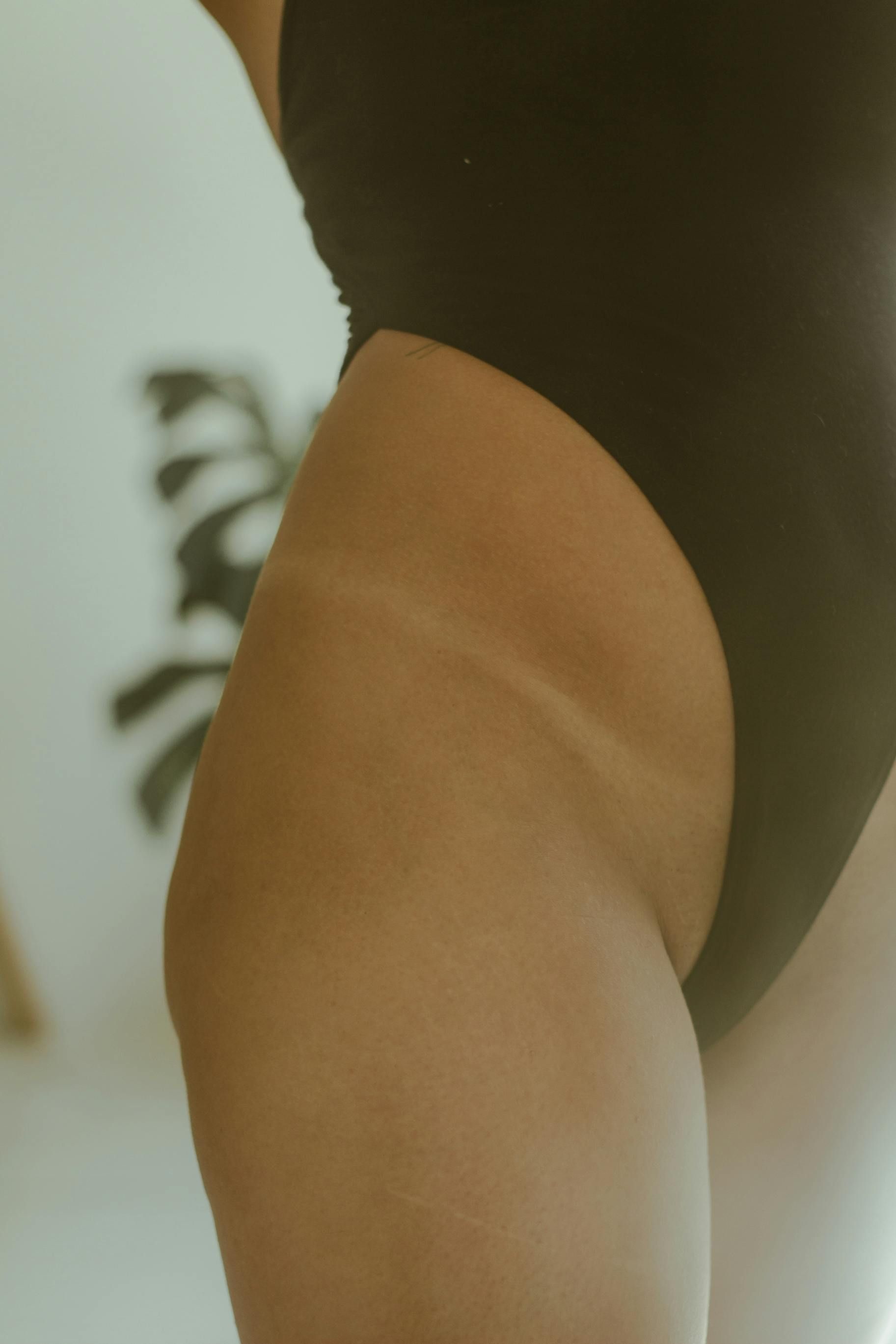 A close up of a woman 's leg in a black swimsuit.