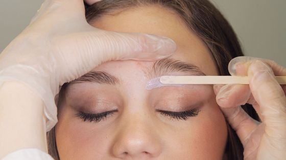 A woman is getting her eyebrows waxed in a beauty salon.