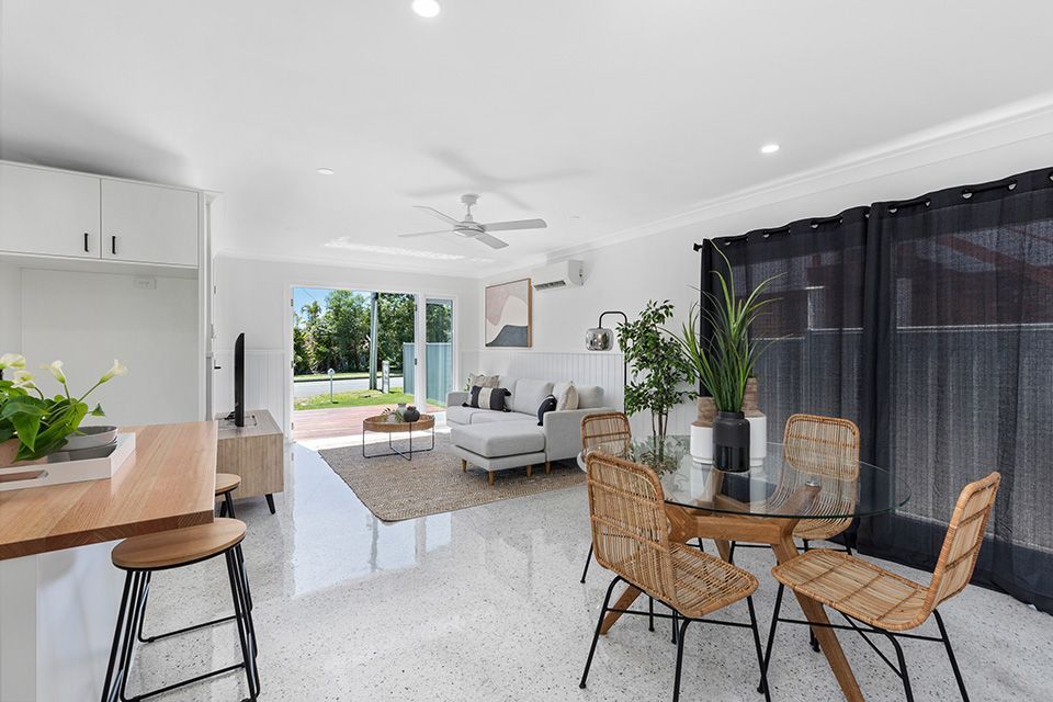 Bright, open-concept living space with dining area, kitchen island, and sliding doors to the patio.