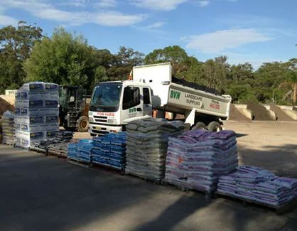A Dump Truck Is Parked Next to A Pile of Bags — BVN Landscape and Concrete Supplies in Nowra, NSW