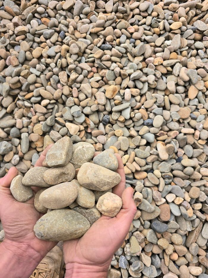 A Person Is Holding a Pile of Rocks in Their Hands — BVN Landscape and Concrete Supplies in St Georges Basin, NSW