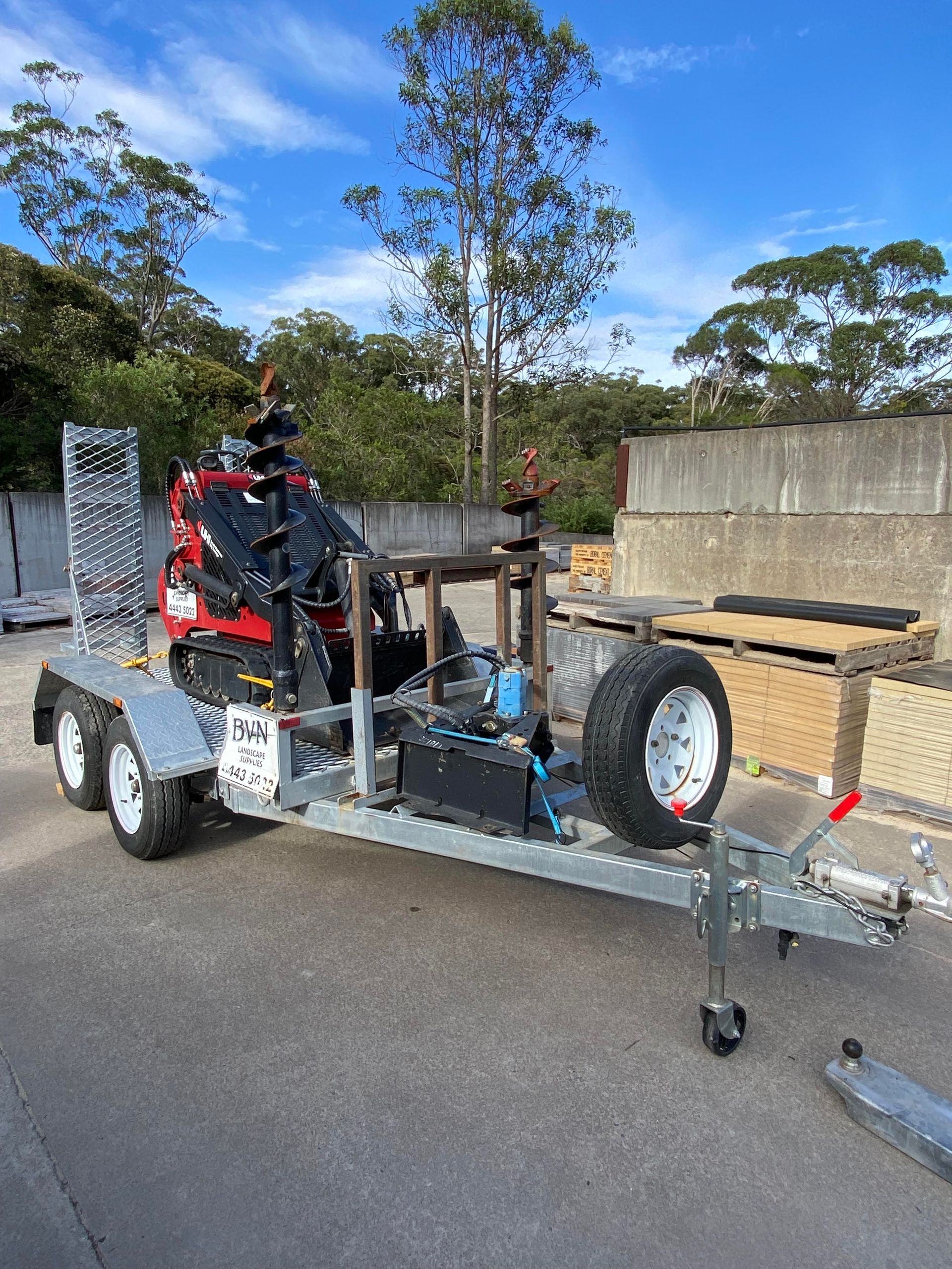 Mini Excavator With Auger on a Trailer, Parked Outdoors — BVN Landscape and Concrete Supplies in St Georges Basin, NSW