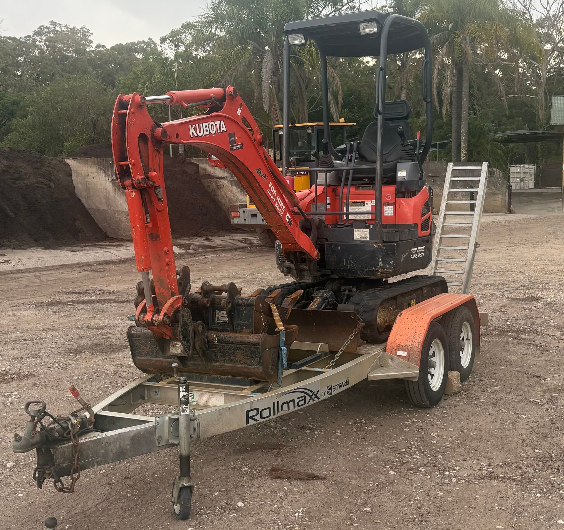 A Small Orange Excavator Is Parked Next to A Large Excavator — BVN Landscape and Concrete Supplies in St Georges Basin, NSW