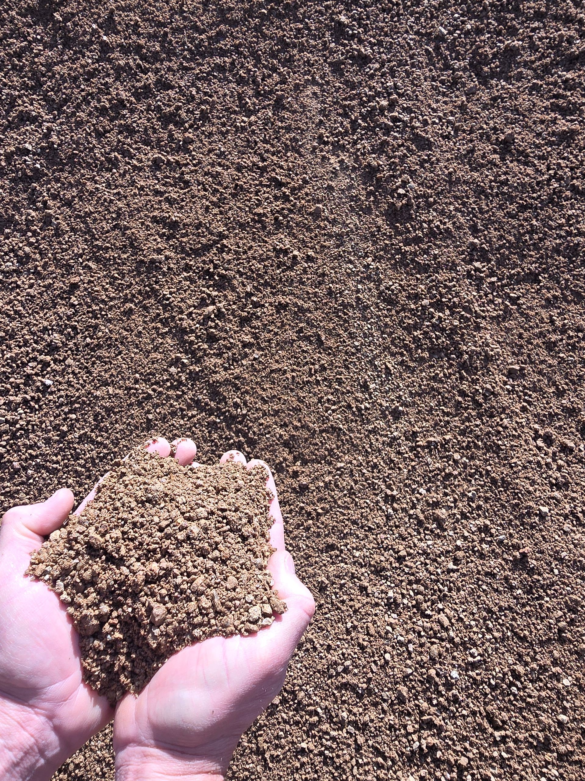 Hands Cupping Handful of Brown, Gravel-like Material — BVN Landscape and Concrete Supplies in Nowra, NSW