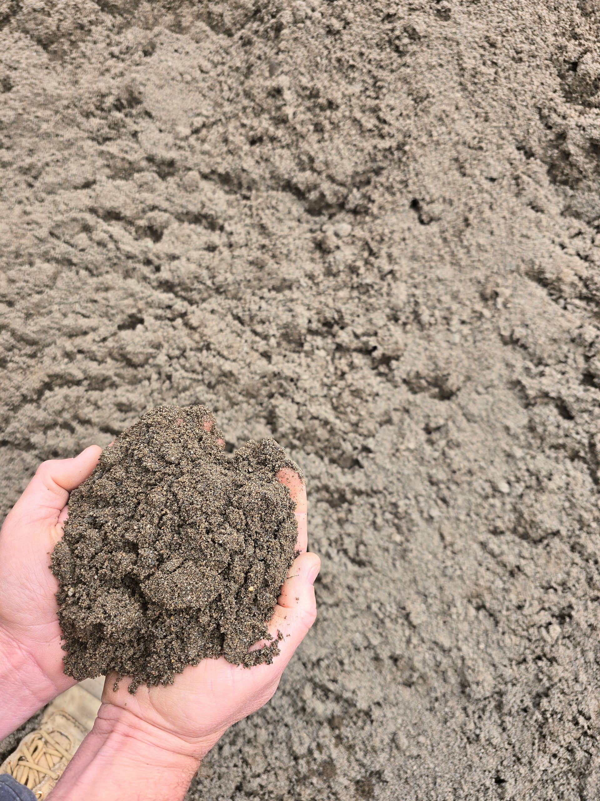Hands Cupped Holding a Handful of Light Brown Sand — BVN Landscape and Concrete Supplies in Vincentia, NSW