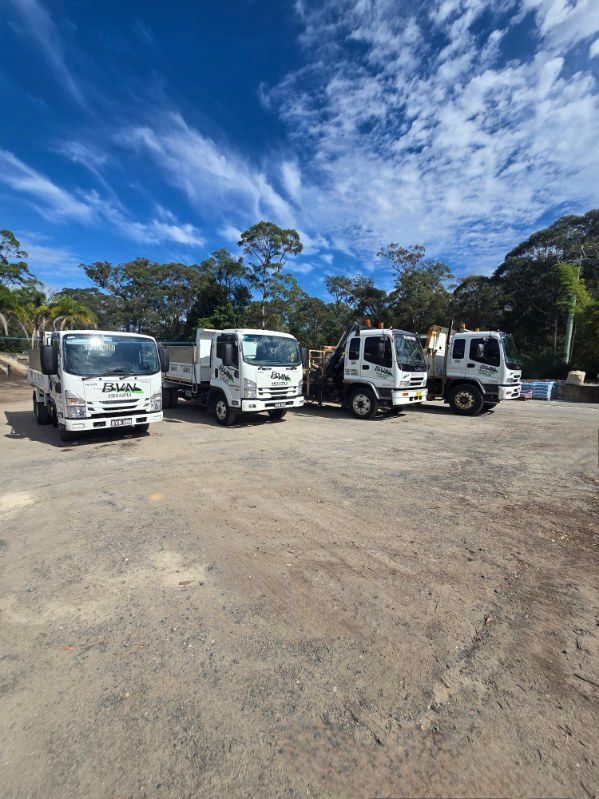 Five White Work Trucks Parked on a Gravel Lot — BVN Landscape and Concrete Supplies in St Georges Basin, NSW