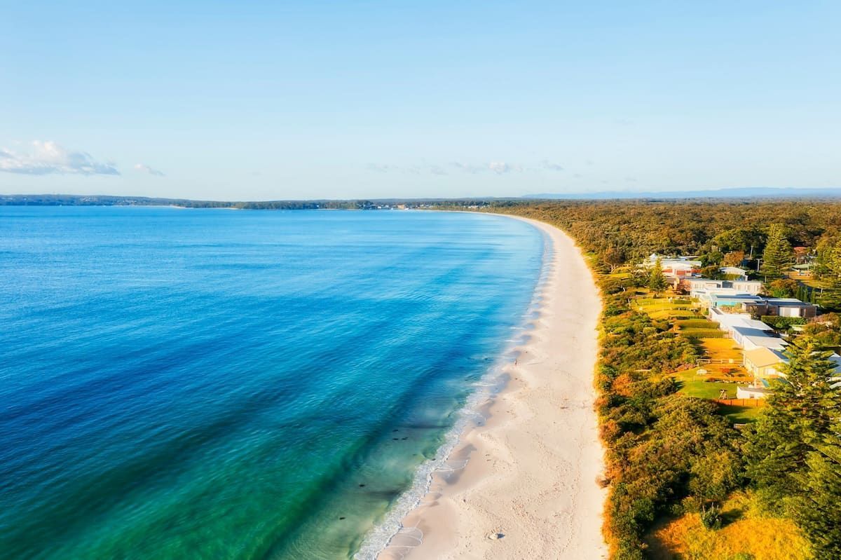 Aerial View of a Sandy Beach Beside Clear Blue Ocean — BVN Landscape and Concrete Supplies in Callala Beach, NSW