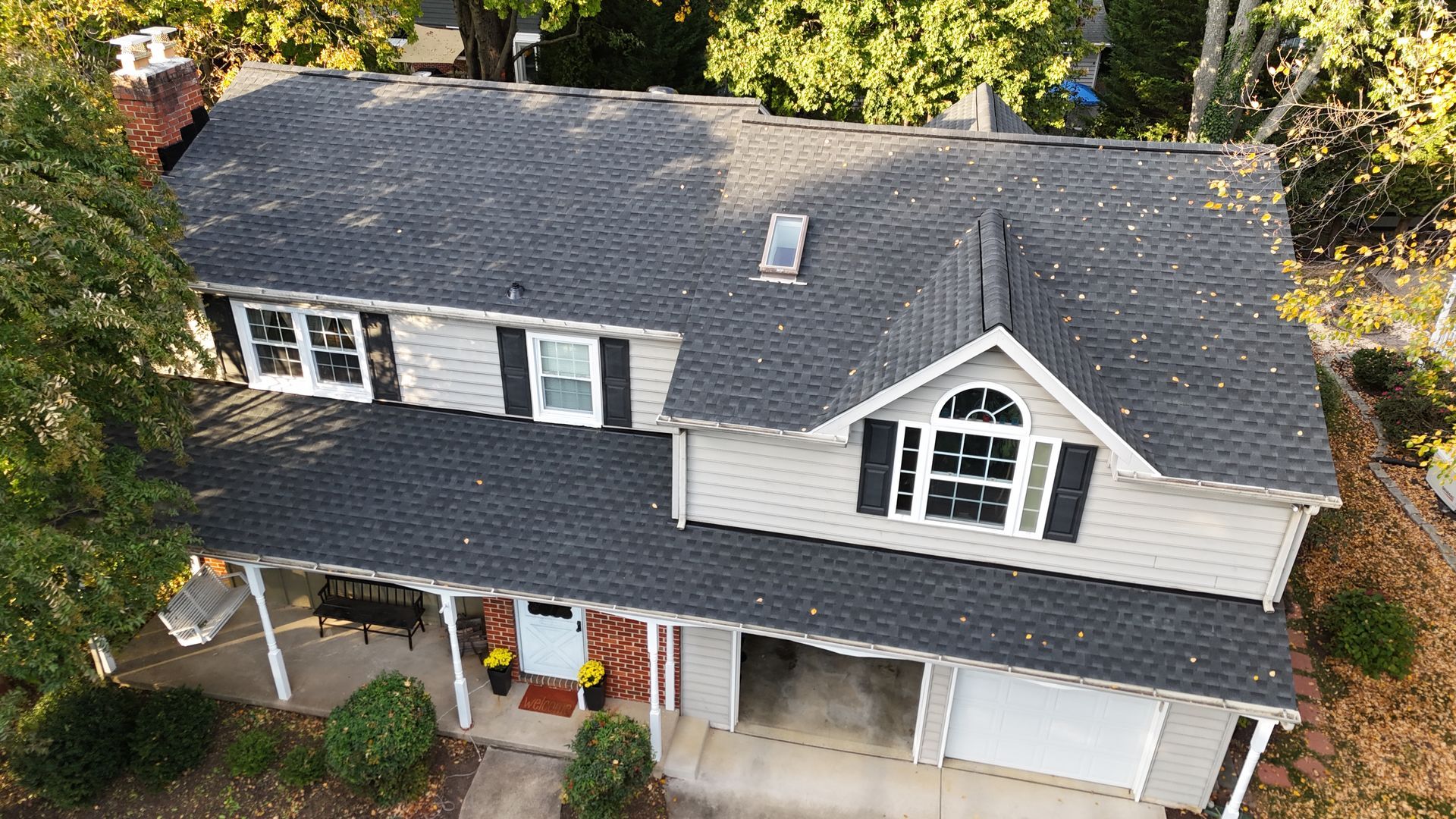An aerial view of a house with a black roof.
