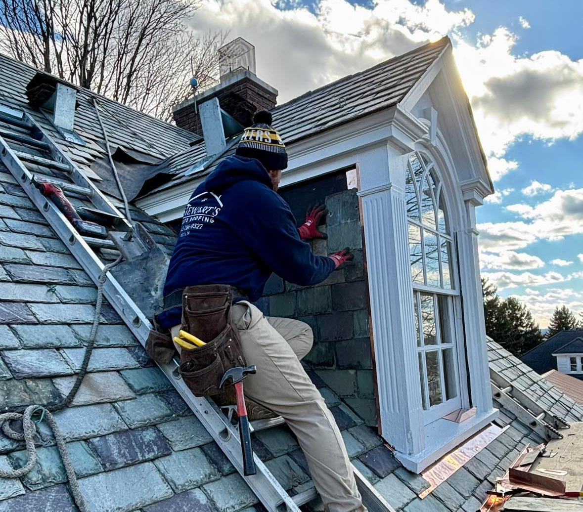 A man is working on a roof with a ladder.