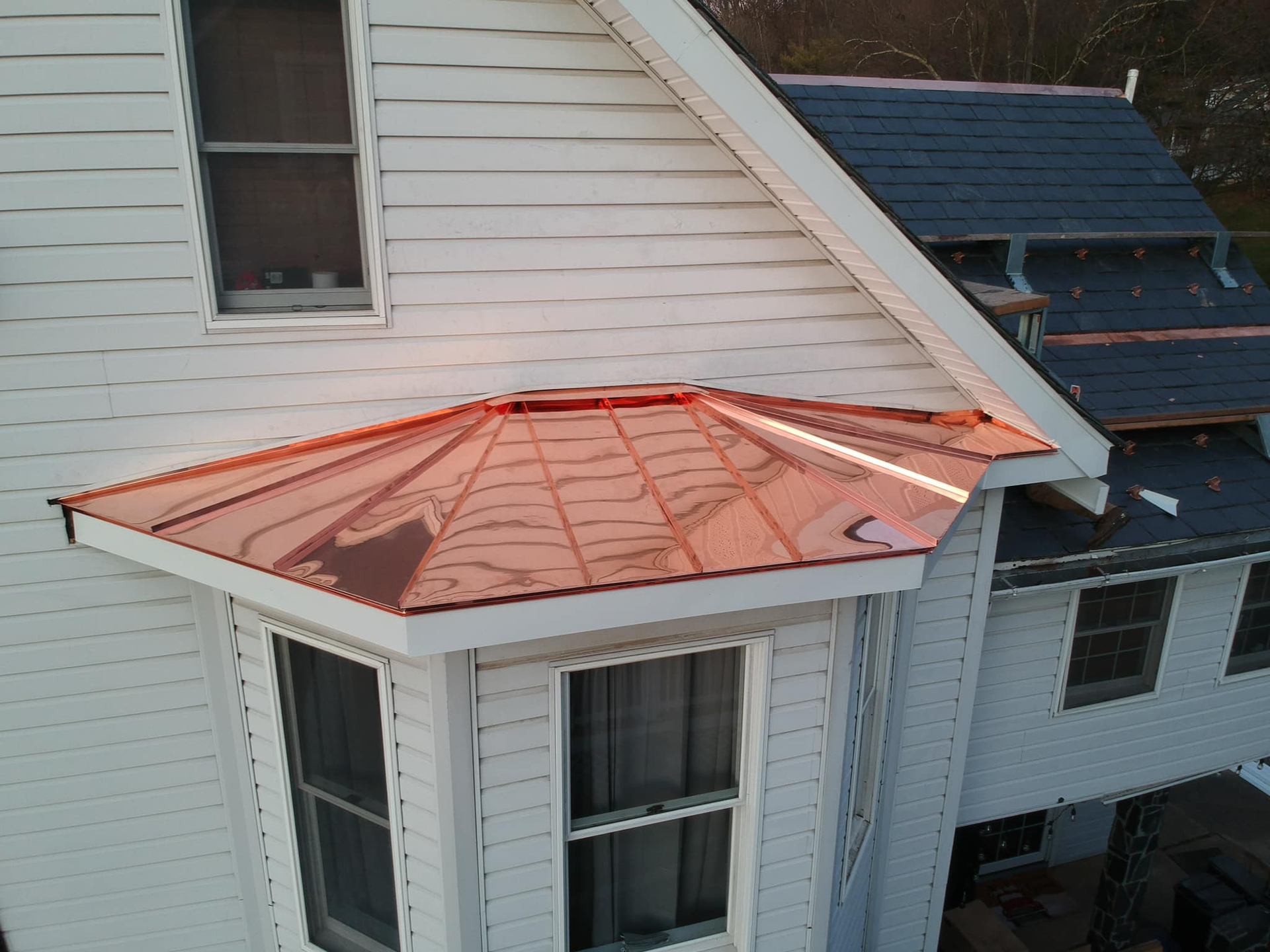 A white house with a copper roof and a window